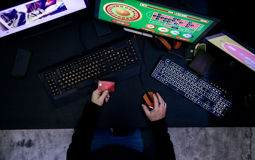 man playing casino online with multiple monitor